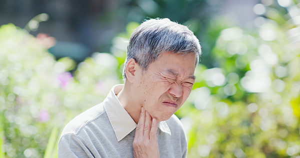 Man suffering from neck or throat issue.