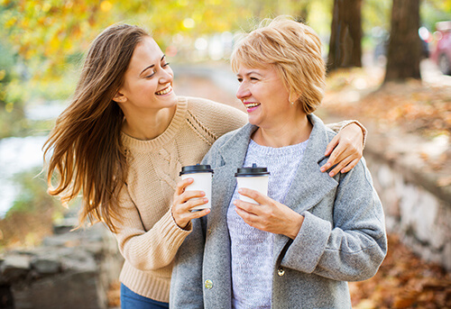 Women enjoying coffee together while walking